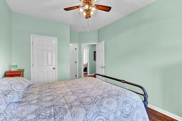 bedroom with dark wood-style flooring, baseboards, and ceiling fan