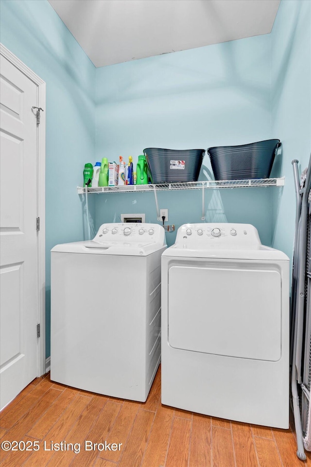 laundry room featuring wood finished floors, separate washer and dryer, and laundry area