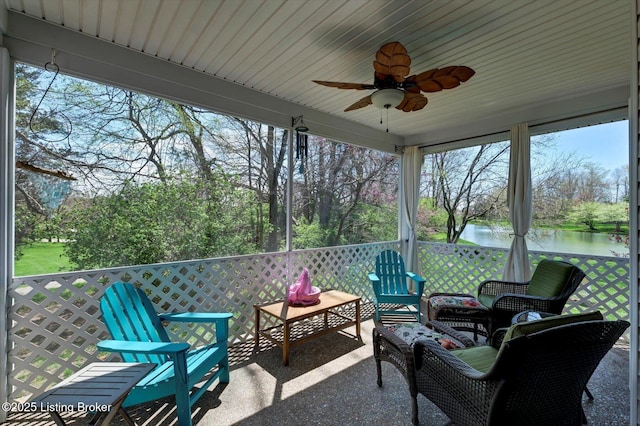 sunroom featuring a water view, plenty of natural light, a ceiling fan, and an outdoor hangout area