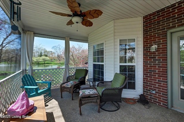 view of patio with a water view and a ceiling fan
