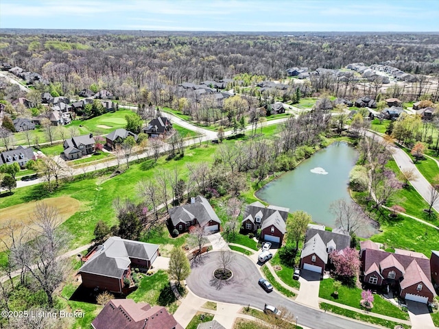 drone / aerial view featuring a water view, a wooded view, and a residential view