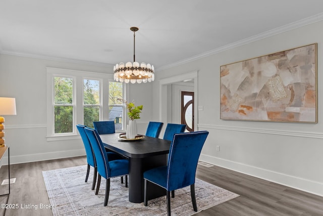 dining area featuring a notable chandelier, baseboards, ornamental molding, and wood finished floors