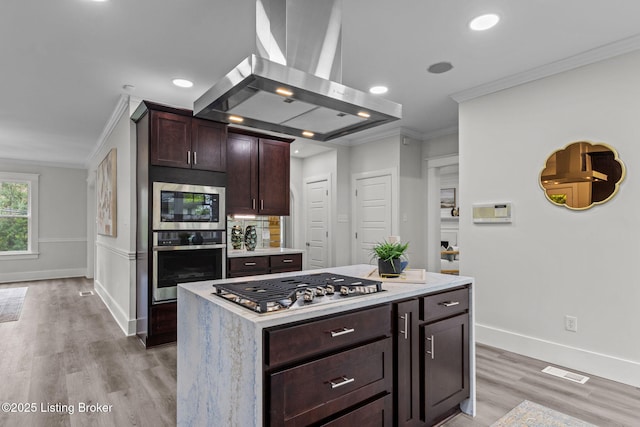 kitchen featuring visible vents, ornamental molding, light countertops, island exhaust hood, and stainless steel appliances
