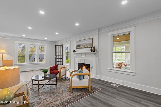 living room featuring visible vents, dark wood-style flooring, a fireplace, crown molding, and recessed lighting