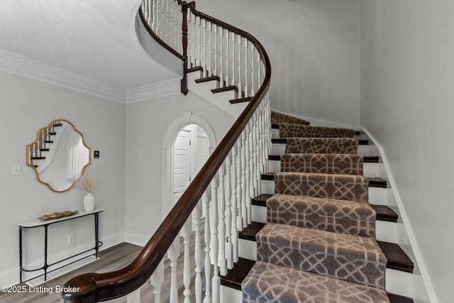 stairs featuring ornamental molding, baseboards, and wood finished floors