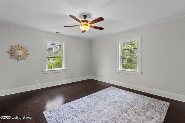 empty room with baseboards, dark wood-style floors, crown molding, a ceiling fan, and visible vents