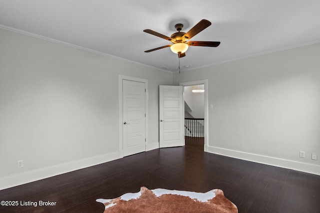 interior space with ornamental molding, baseboards, a ceiling fan, and wood finished floors