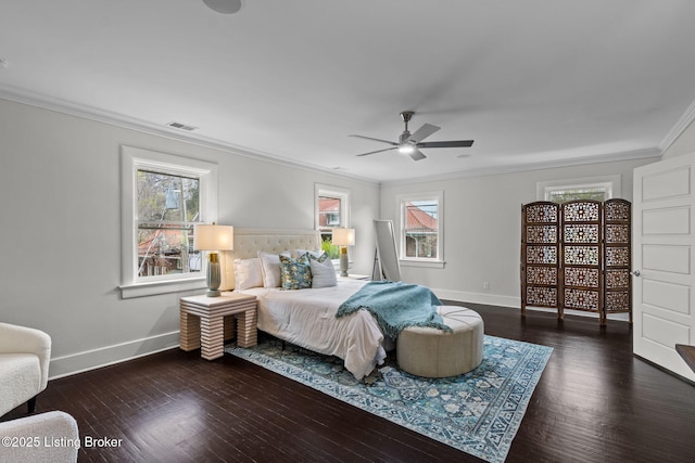 bedroom with wood finished floors, multiple windows, baseboards, and ornamental molding