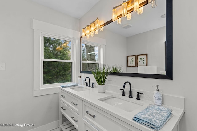 bathroom with a sink, visible vents, double vanity, and a chandelier