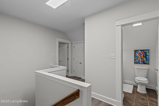 hall with an upstairs landing and baseboards