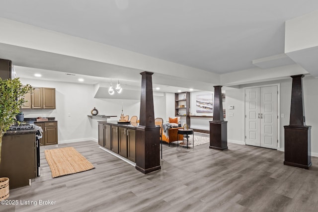 interior space with recessed lighting, baseboards, light wood-type flooring, and decorative columns