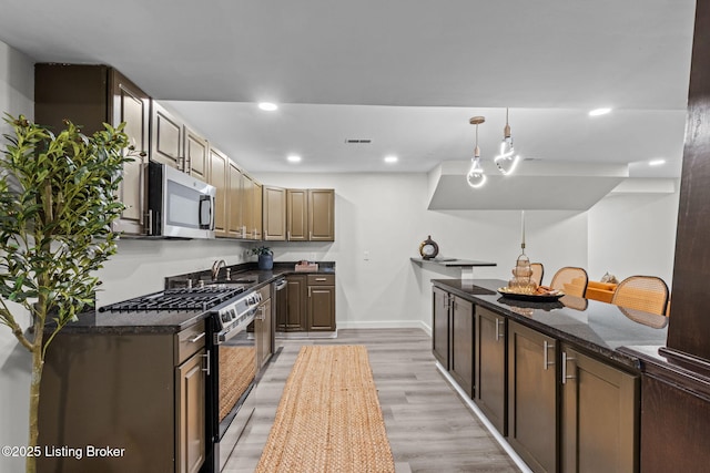 kitchen featuring visible vents, baseboards, light wood-style floors, recessed lighting, and stainless steel appliances