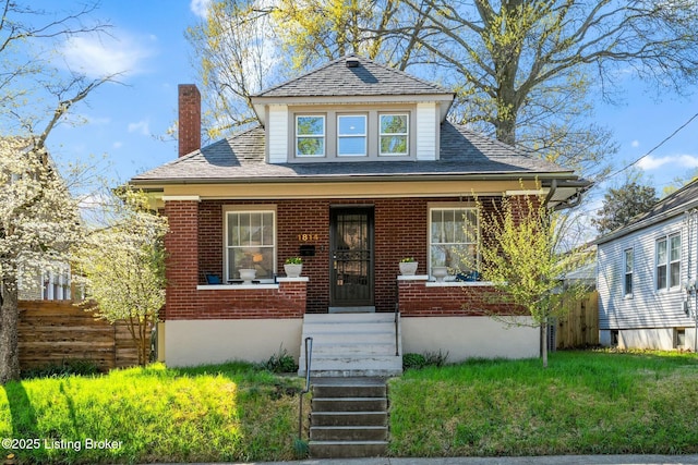bungalow-style house with roof with shingles, a chimney, covered porch, and brick siding