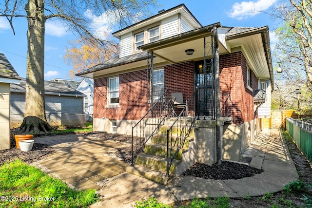 view of front of property featuring brick siding and fence