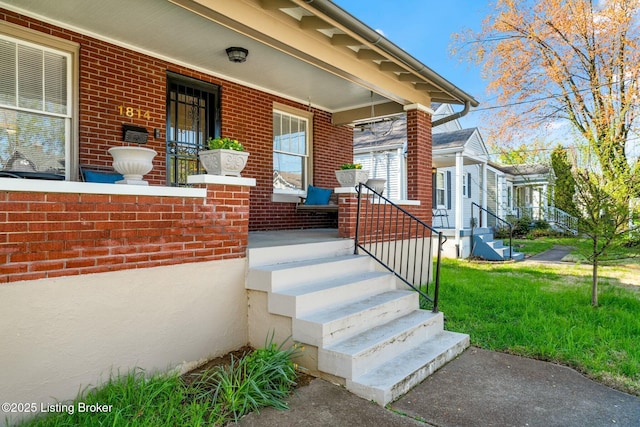 entrance to property with brick siding and covered porch