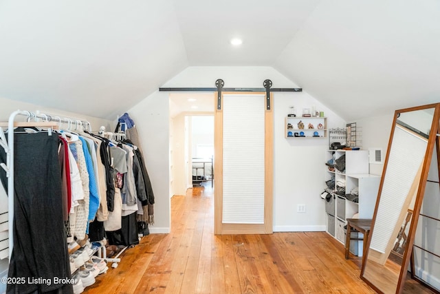 spacious closet with light wood-style flooring and lofted ceiling