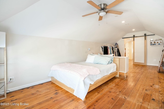 bedroom featuring light wood-style flooring, baseboards, vaulted ceiling, and a ceiling fan