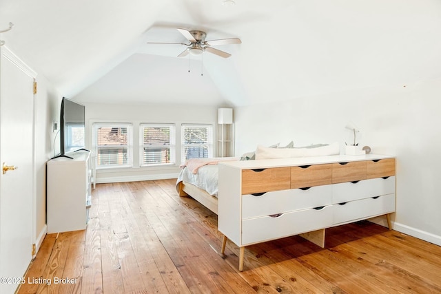 bedroom featuring baseboards, light wood finished floors, ceiling fan, and vaulted ceiling