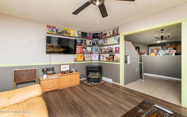 310 Wentworth Ave, Bedford, KY 40006 - living area with a wood stove, ceiling fan with notable chandelier, a textured ceiling, and wood finished floors