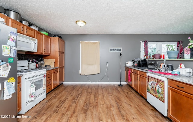 310 Wentworth Ave, Bedford, KY 40006 - kitchen featuring a sink, brown cabinetry, white appliances, and light wood-style floors