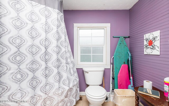 310 Wentworth Ave, Bedford, KY 40006 - bathroom featuring a shower with shower curtain, baseboards, tile patterned flooring, a textured ceiling, and toilet