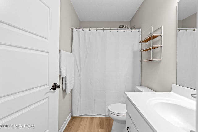 full bath featuring vanity, curtained shower, a textured ceiling, toilet, and wood finished floors