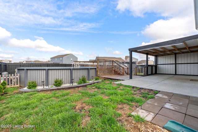 view of yard with a deck, fence, and a fenced in pool