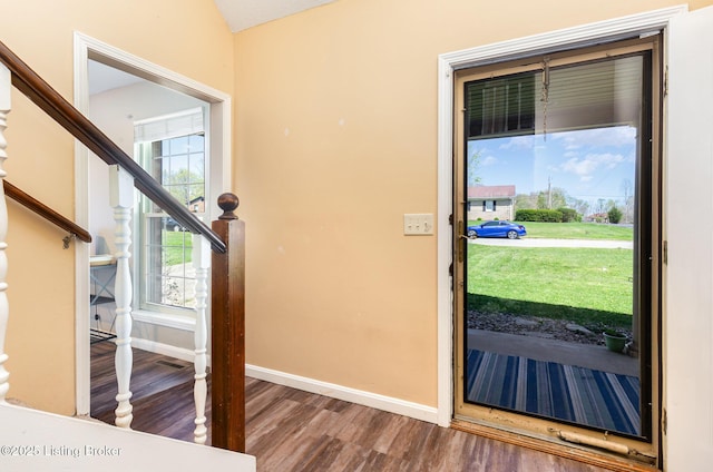 entrance foyer featuring stairway, baseboards, lofted ceiling, and wood finished floors