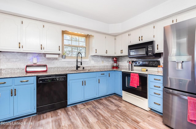 kitchen featuring white cabinets, blue cabinetry, a sink, and black appliances