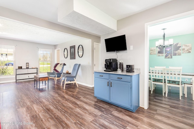 interior space with a notable chandelier, dark wood-style flooring, and baseboards