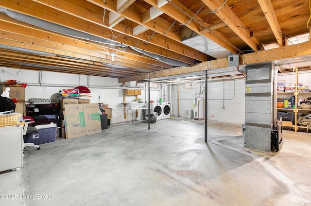 unfinished basement with water heater and separate washer and dryer