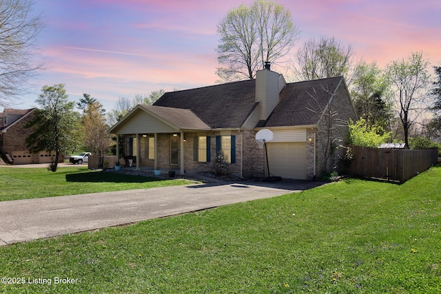 ranch-style home featuring a garage, fence, a front lawn, brick siding, and driveway