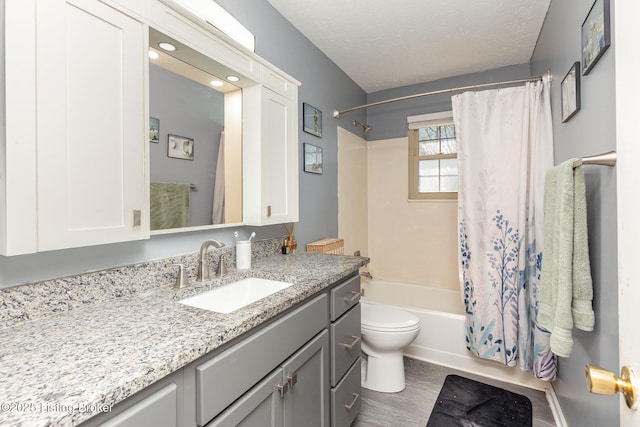 full bathroom with a textured ceiling, shower / bathtub combination with curtain, vanity, toilet, and wood finished floors
