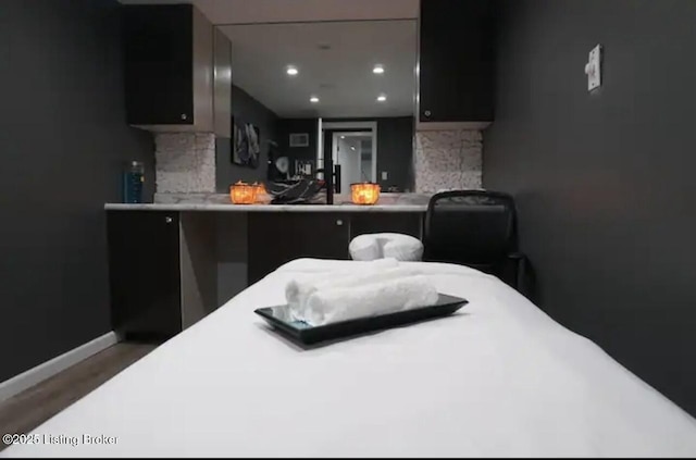 bedroom with wood finished floors, baseboards, and recessed lighting