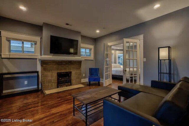 living area featuring baseboards, a fireplace, recessed lighting, french doors, and wood finished floors
