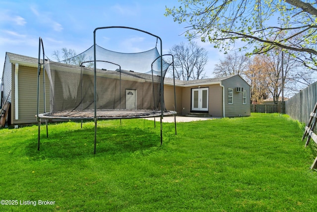 8006 Bramble Ln, Louisville, KY 40258 - rear view of property with a trampoline, french doors, fence, and a lawn