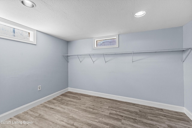 8006 Bramble Ln, Louisville, KY 40258 - below grade area with baseboards, plenty of natural light, wood finished floors, and a textured ceiling