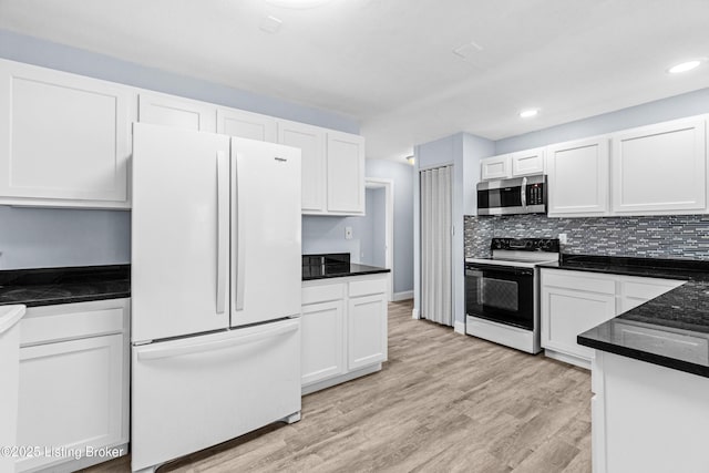 8006 Bramble Ln, Louisville, KY 40258 - kitchen featuring white cabinetry, stainless steel microwave, freestanding refrigerator, and electric range