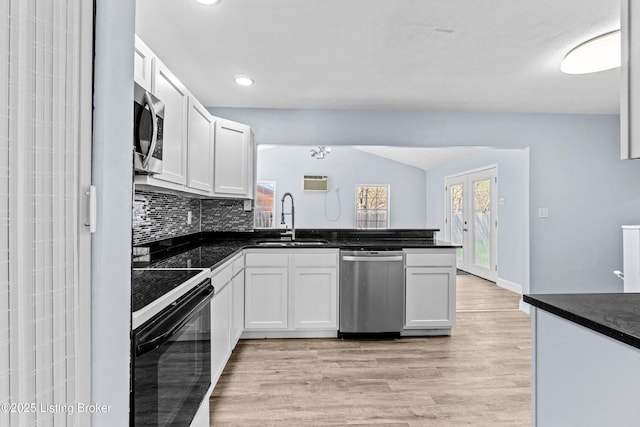8006 Bramble Ln, Louisville, KY 40258 - kitchen with a peninsula, light wood-style flooring, dark countertops, appliances with stainless steel finishes, and a sink
