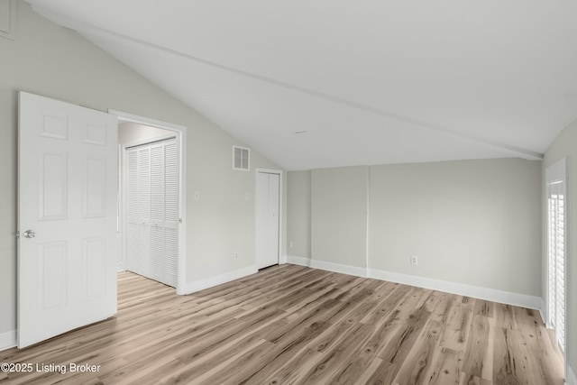 bonus room featuring light wood-type flooring, baseboards, vaulted ceiling, and visible vents