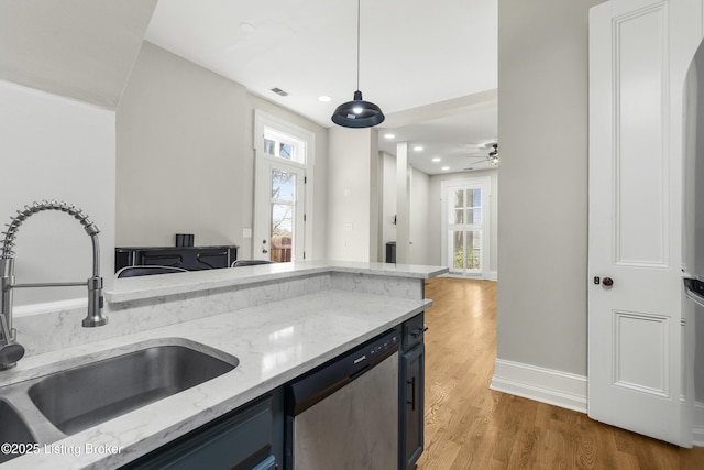 kitchen with a sink, stainless steel dishwasher, light wood finished floors, and a wealth of natural light