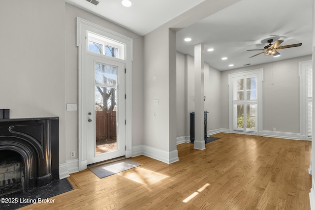 foyer with a fireplace with flush hearth, light wood-style floors, and plenty of natural light
