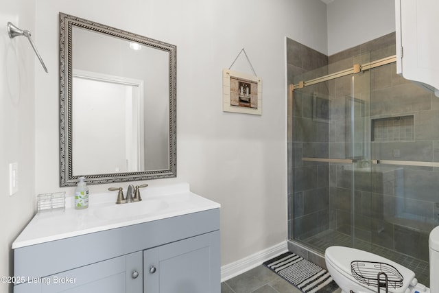 bathroom with toilet, a stall shower, vanity, and baseboards