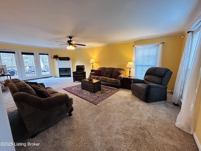 living room with plenty of natural light, ornamental molding, carpet, and ceiling fan