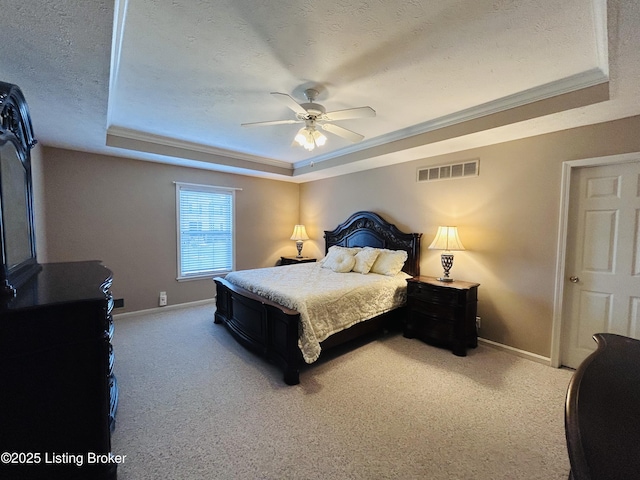 carpeted bedroom featuring a tray ceiling, visible vents, baseboards, a textured ceiling, and ceiling fan