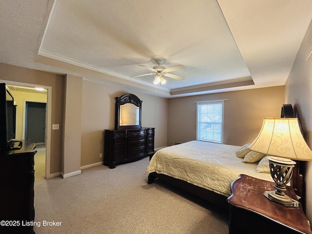 bedroom with a tray ceiling, carpet, baseboards, and ceiling fan