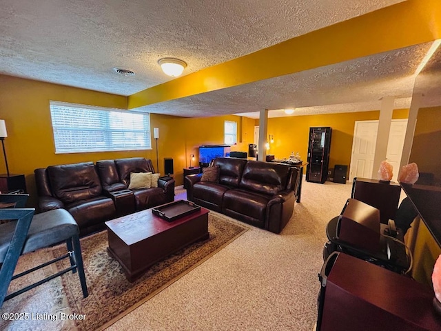living room with a textured ceiling, visible vents, and carpet