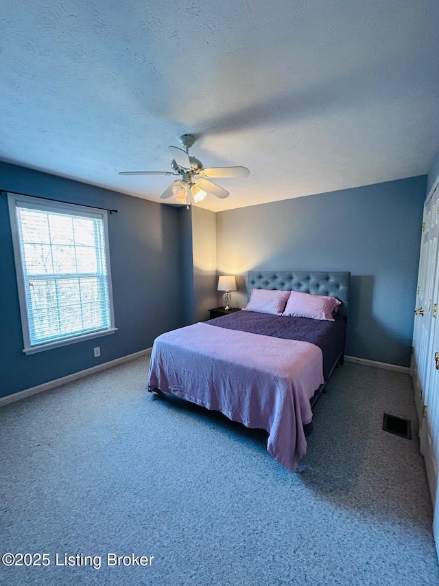 bedroom featuring baseboards, visible vents, carpet, and a textured ceiling