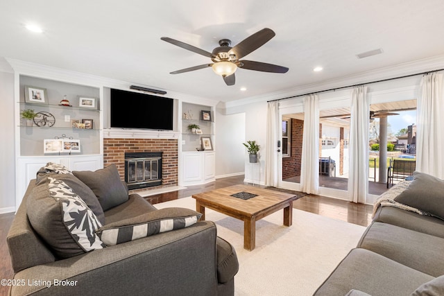 living room with baseboards, ornamental molding, recessed lighting, a ceiling fan, and built in shelves