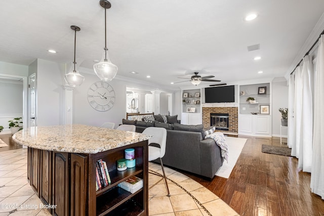 kitchen featuring dark brown cabinetry, built in features, recessed lighting, a center island, and ceiling fan